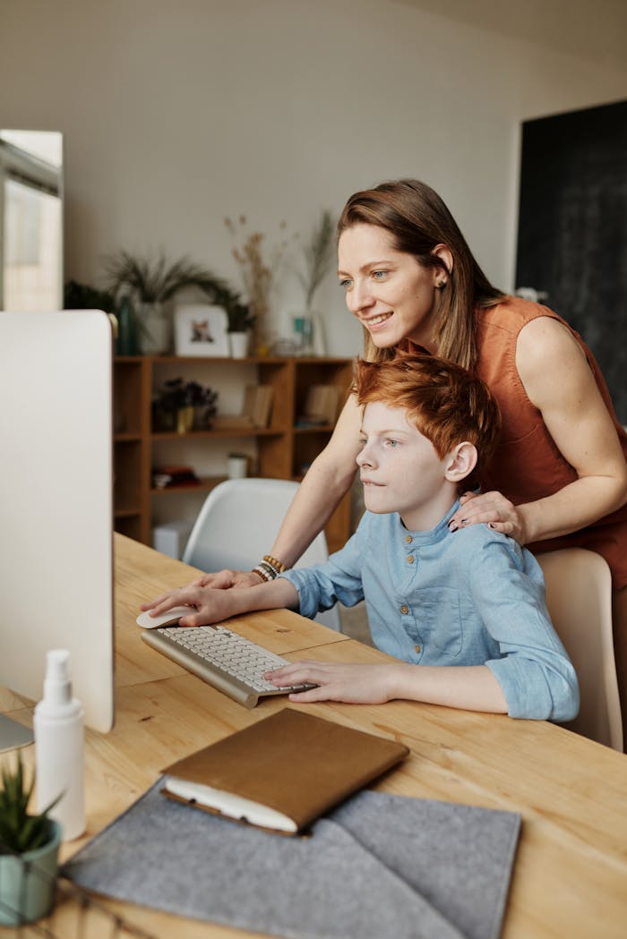 services-02 A mother helps her son with online learning on a home computer.